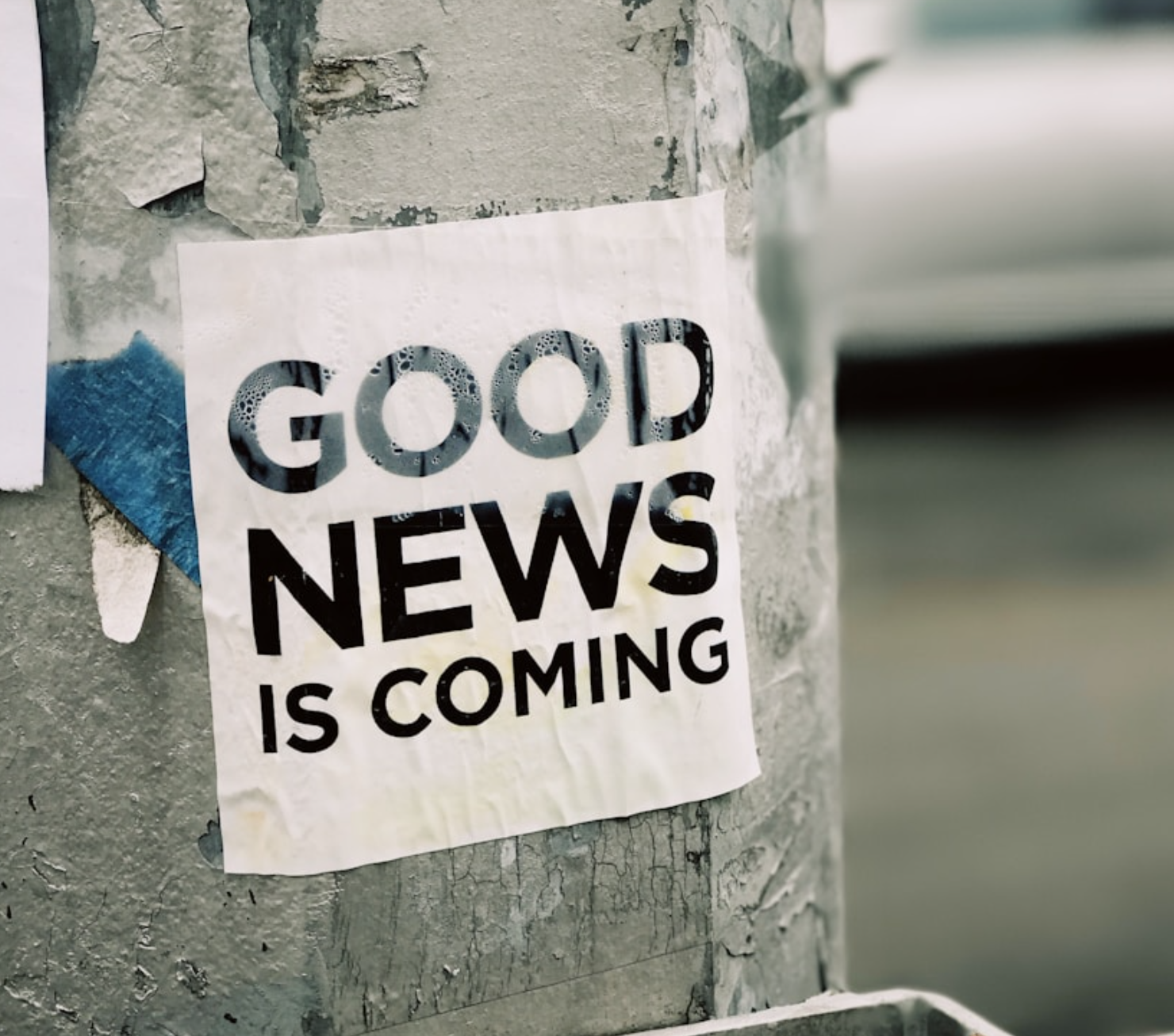 white Good News Is Coming paper on wall